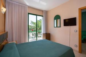a bedroom with a bed and a large window at ALEGRIA Pino Alto in Miami Platja