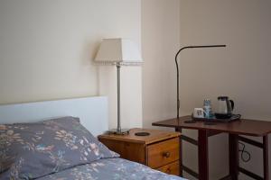 a bedroom with a bed and a desk with a lamp at Monument View in Hexham