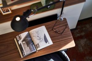 a table with a book and a lamp on it at hood house in Hamburg