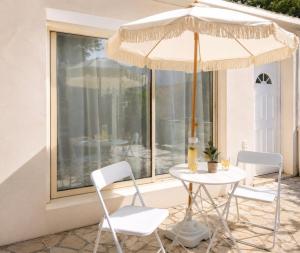 a table and chairs with an umbrella on a patio at Nüma Studio - Orly Paris in Montgeron