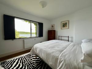 a bedroom with a bed and a large window at 4 Harbour Town House in Westport