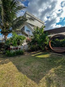 a house with a palm tree and a fence at The Hermitage Tagaytay-Junior Suite in Malabag