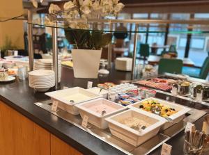 ein Buffet mit Speisen auf einem Tisch in der Unterkunft Olymp Munich in Eching