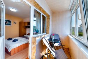 a small bedroom with a bed and two windows at Walter Waves Private Apartment with Balcony and Self Check-In in Costinesti