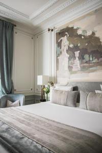a bedroom with a large bed and a painting on the wall at Hôtel Elysia by Inwood Hotels in Paris