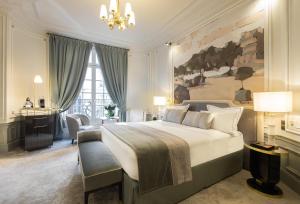 a bedroom with a large white bed and a desk at Hôtel Elysia by Inwood Hotels in Paris
