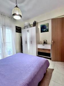 a bedroom with a purple bed and a dresser at Galini Apartments in Litochoro +12 photos