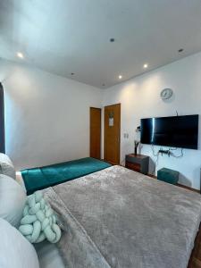 a bedroom with a large bed and a flat screen tv at The Hermitage Tagaytay-Junior Suite in Malabag +22 photos