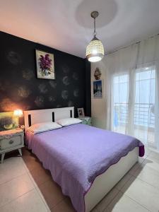 a bedroom with a large bed with a purple bedspread at Galini Apartments in Litochoro