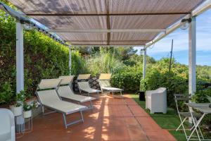 a pergola with chairs and tables on a patio at Piccolo Paradiso - Montenero in Montenero