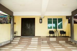 a hallway with two chairs and a door at Aisya homestay jerteh in Jertih