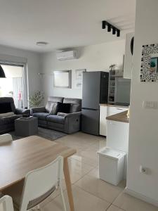 a kitchen and living room with a couch and a table at Apartma LAVANDA 3 Šilo in Šilo
