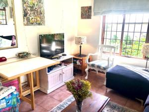 a living room with a television and a bed and a table at The Owls Nest in Lakeside