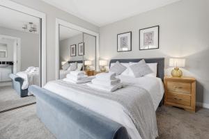 a bedroom with a large bed with white sheets and pillows at Glenisla, Aviemore, fantastic location with sauna and hot tub in Aviemore