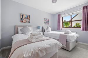 a bedroom with two beds and a window at Glenisla, Aviemore, fantastic location with sauna and hot tub in Aviemore