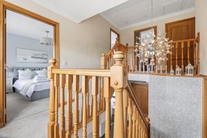 a wooden staircase in a bedroom with a chandelier at Glenisla, Aviemore, fantastic location with sauna and hot tub in Aviemore +33 photos
