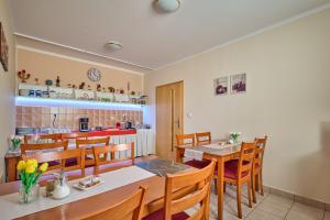 a dining room with tables and chairs and a kitchen at Penzion Aida Ostrava in Ostrava