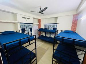 a room with three bunk beds and a ceiling at Phalchaa Stay in Jaigaon