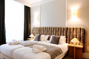 two beds in a hotel room with towels on them at Résidence Monceau Jadin in Paris