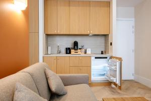 a living room with a couch and a kitchen at Résidence Monceau Jadin in Paris +9 photos