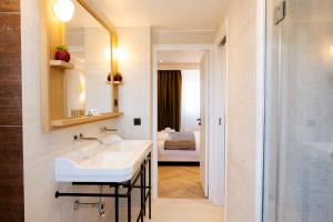 a bathroom with a sink and a mirror and a bedroom at Résidence Monceau Jadin in Paris