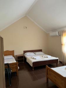 a bedroom with two beds and a table and a window at Liza's house - Block B in Ureki +4 photos