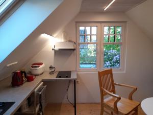a kitchen with a table and a chair and a window at Männi hoovimaja in Pärnu