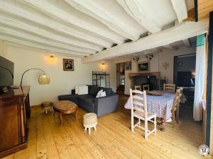 a living room with a couch and a table at Le gîte des oiseaux in Aisy-sous-Thil