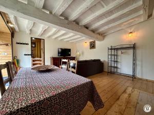 a living room with a bed and a couch at Le gîte des oiseaux in Aisy-sous-Thil