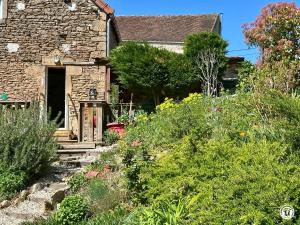 an old stone house with a garden in front of it at Le gîte des oiseaux in Aisy-sous-Thil