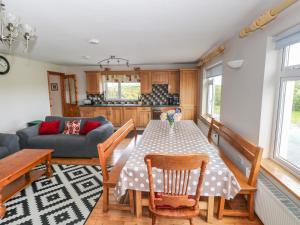 a kitchen and living room with a table and chairs at Islands Inn in Louisburgh