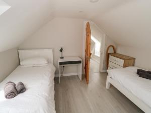 two beds in a room with a desk and a bedroom at Islands Inn in Louisburgh