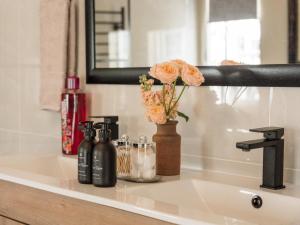 a bathroom sink with a vase with flowers on it at Fiore Guest Accommodation in Greyton