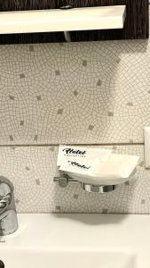 a toilet paper dispenser on a white tiled wall at Motel in Sarny +26 photos