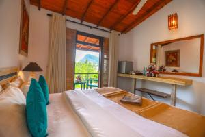 a bedroom with a large bed and a mirror at Amber Reach Cottages in Ella