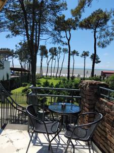 a patio with a table and chairs and the beach at Old House Ureki in Ureki