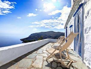 two chairs sitting on a balcony overlooking the ocean at Blue Horizon in Hydra