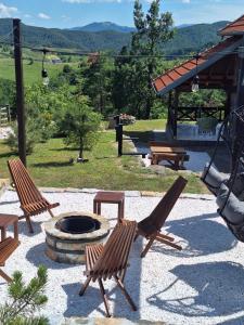 a patio with two chairs and a fire pit at Planinska kuća Radulović in Goč