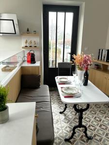 a kitchen with a table and a white table and a couch at Relais Fléchois in La Flèche