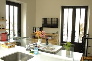 a kitchen with a sink and a tv on the wall at Relais Fléchois in La Flèche +11 photos