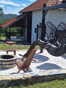 a patio with two swings and a fire place at Planinska kuća Radulović in Goč