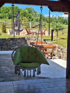 a green chair hanging from a gazebo at Planinska kuća Radulović in Goč