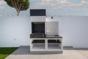 a kitchen with a tv on a white wall at Sumatra 1 in Novo Sancti Petri