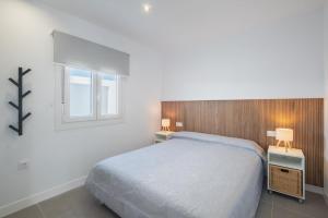 a bedroom with a bed and two tables and a window at Sumatra 1 in Novo Sancti Petri