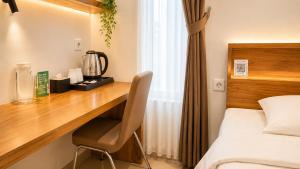 a desk in a hotel room with a bed and a bed at Baliem Boutique Hotel Ungasan in Jimbaran
