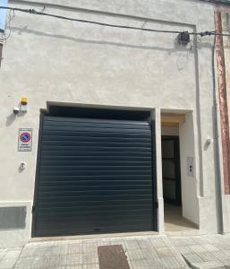 a black garage door on the side of a building at Leonardo in Veglie