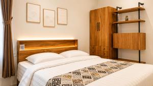 a bedroom with a bed with a wooden headboard at Baliem Boutique Hotel Ungasan in Jimbaran