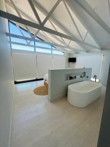 a room with a large white tub in the middle of a room at Sunset Villa Herolds Bay in Herolds Bay +39 photos