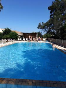 a large swimming pool with people in the water at 2BR Apt Kitchenette Pool 6 in Gouvia