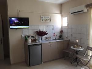 a kitchen with a sink and a tv on the wall at Studio Gouvia Kitchenette Pool 5 in Gouvia +34 photos
